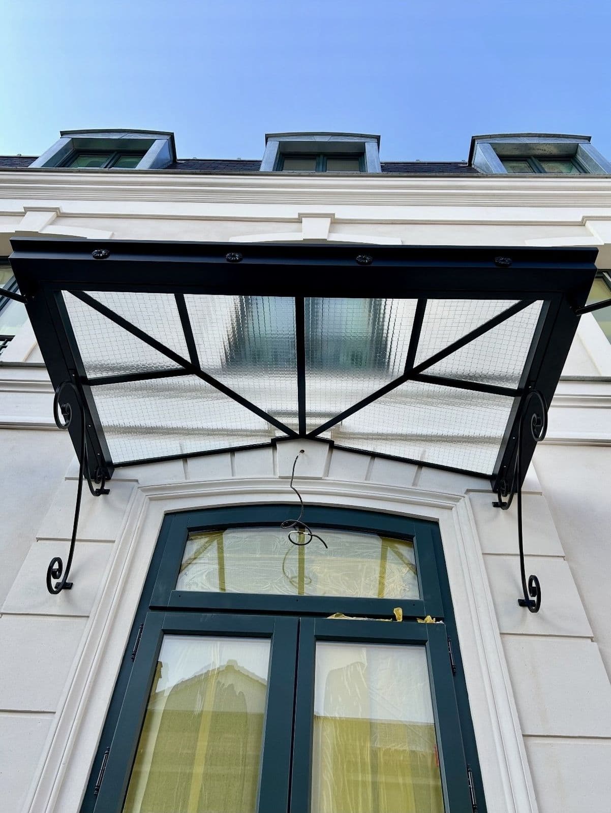 Marquise ferronnée sur façade blanche